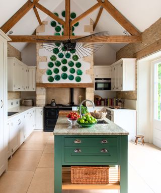 Neutral country kitchen with a green island and green wall plates, photograph Rachel Smith