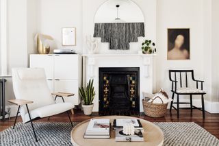 white and grey living room with round coffee table and white armchair