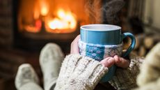 Warming and relaxing near fireplace with a cup of hot drink