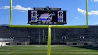 A view of the Michigan State videoboard through the goal post of the opposing end zone. 