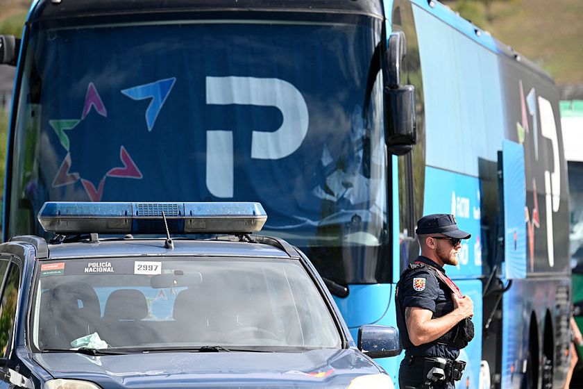 A National Police officer stands guard next to Team Israel Premier Tech&#039;s bus in Vegadeo at the start of the 15th stage of the Vuelta a Espana cycling tour, a 167 km race between A Veiga/Vegadeo and Monforte de Lemos, on September 7, 2025. (Photo by MIGUEL RIOPA / AFP)