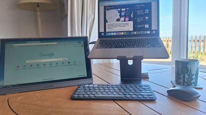 Portable desk setup with the seaside visible through a window in the background