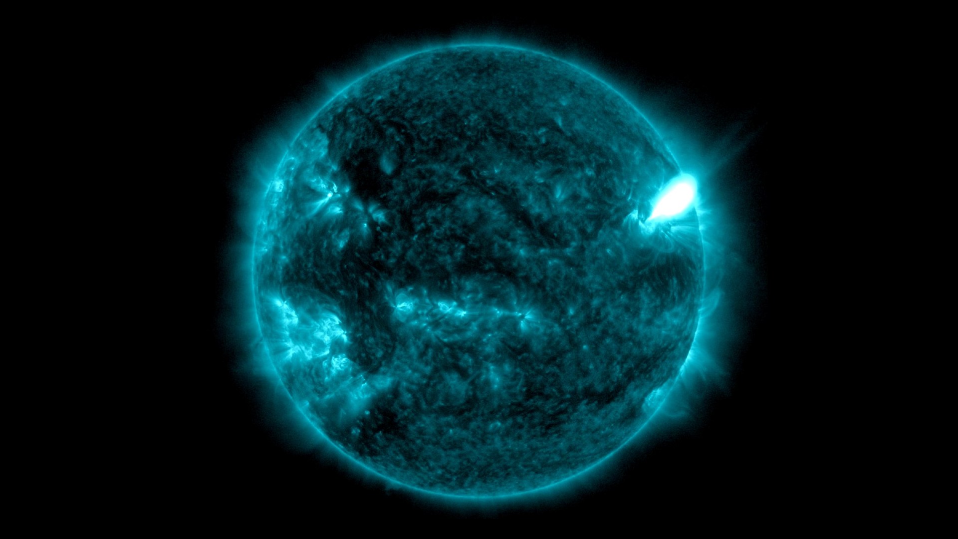 a bright flare extends outward from the sun
