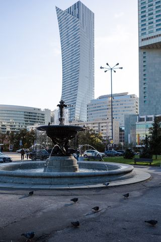 Stone fountain with Warsaw tower in the background