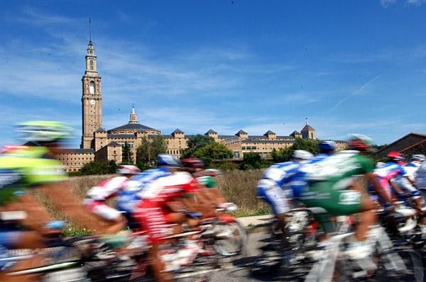 The peloton zooms by the scenic buildings in Spain