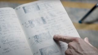 someone pointing to hand drawn storyboards in a notebook