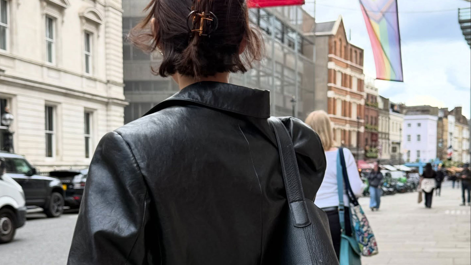 @smythsisters street style shot from the back with claw clip, leather jacket, and black bucket bag