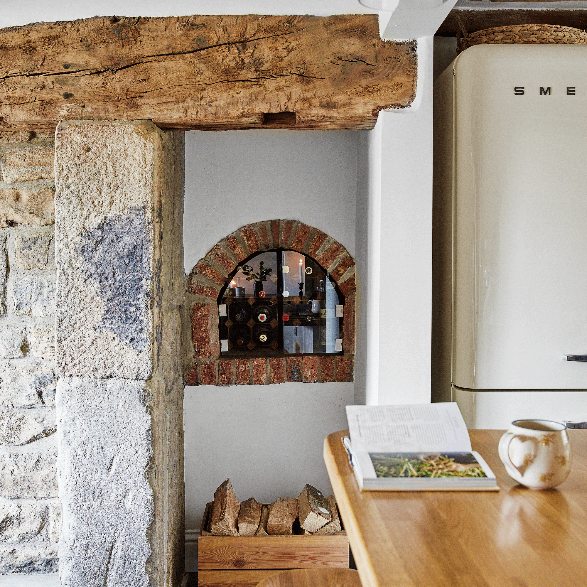 a rustic kitchen with a traditional wall oven cavity repurposed as wine storage