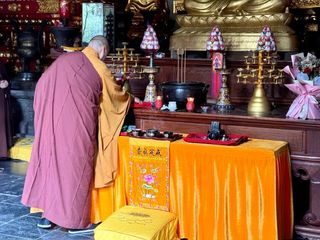 A Buddhist monk blesses a Hasselblad film camera at the Shaolin Temple in Henan, China