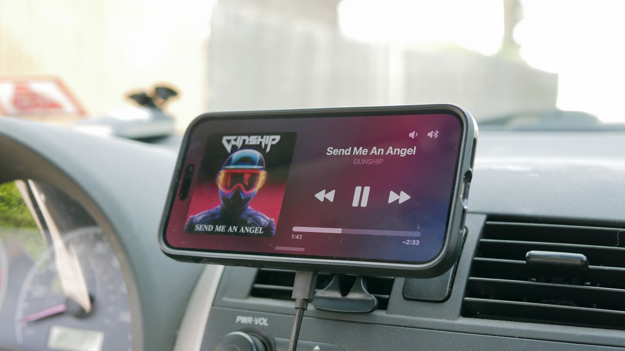ESR HaloLock MagSafe Car Charger attached to vent clip in car with iPhone.