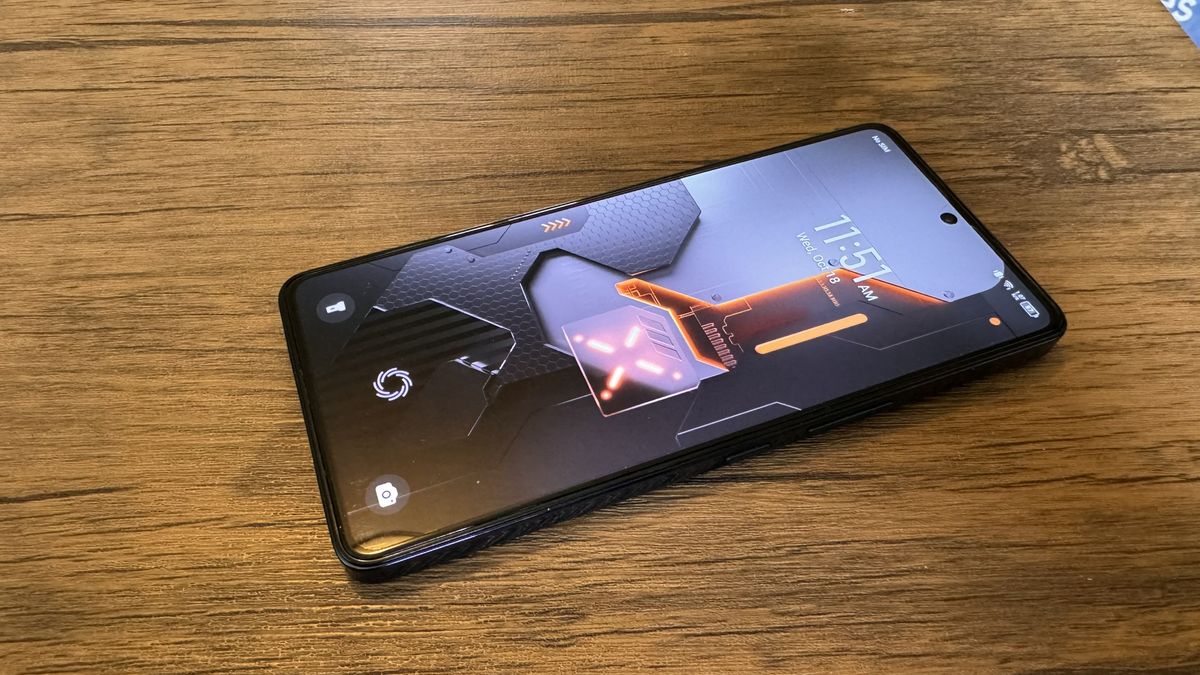 A Cyber Black Infinix GT 10 Pro camera phone on a brown wooden table