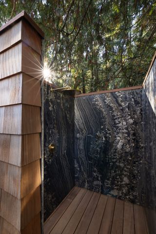 an outdoor shower with a stone surface