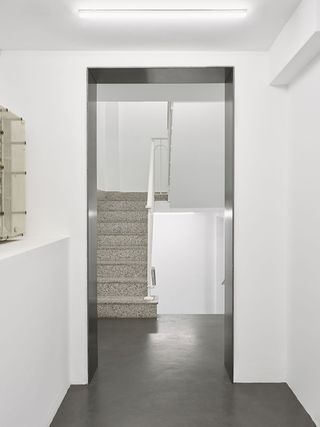 Stairwell with white walls and metal lined arch