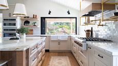 kitchen sink ideas, kitchen with pale pink cabinetery, black window frame, large sink, black wall lights vaulted shiplap ceiling, open shelving, kitchen island