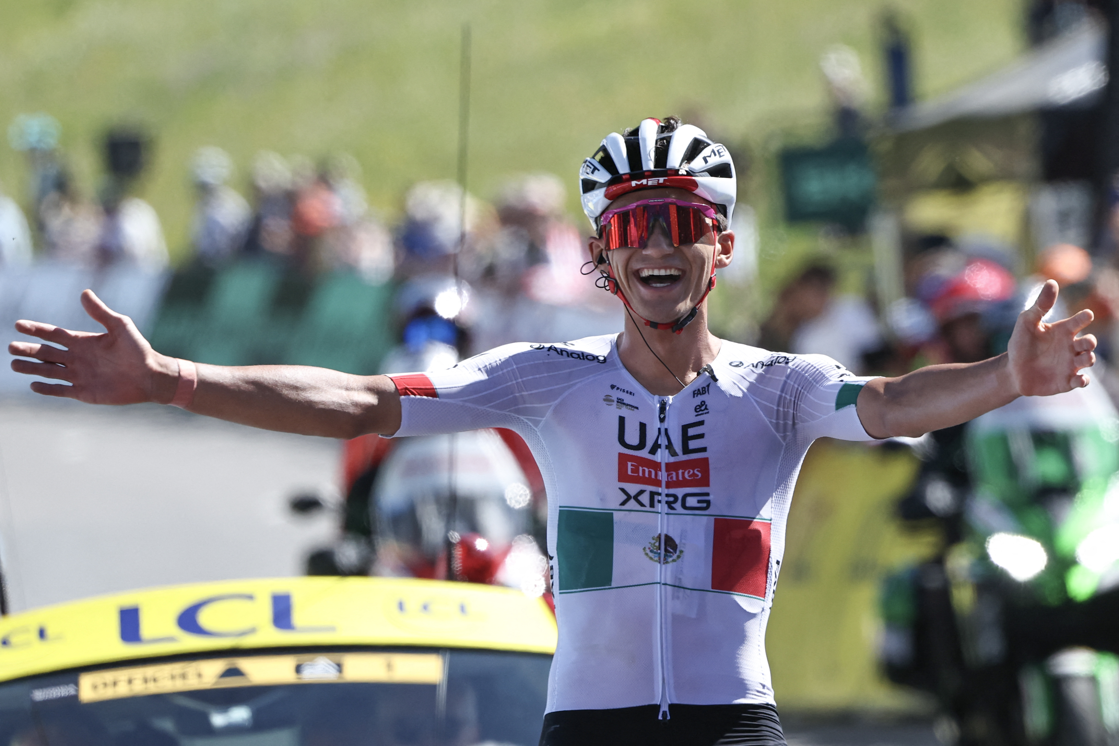 UAE Team Emirates XRG's Mexican rider Isaac Del Toro Romero celebrates as he cycles to the finish line to win the 8th and final stage of the Tour Auvergne-Rhone-Alpes cycling race (formerly known as the Criterium du Dauphine), 120,1km between Beaufort and Plateau de Solaison, in the French Alps on June 14, 2026. (Photo by Anne-Christine POUJOULAT / AFP)