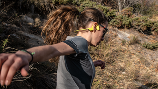 Woman wearing Suunto Sonic bone conduction running headphones