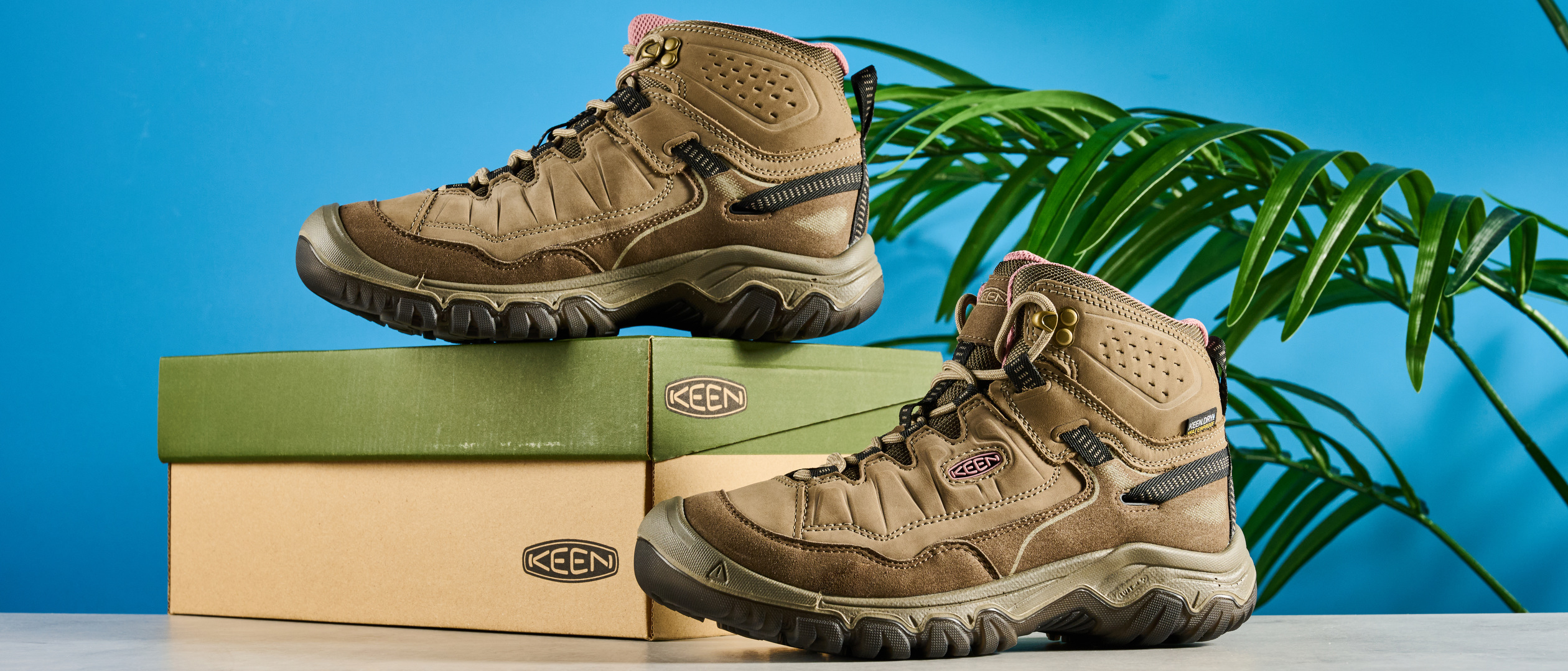 Keen Targhee IV hiking boots photographed in front of a blue background. 