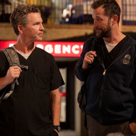 Two doctors look at each other while holding their backpack straps, as they leave an emergency room at night, in 'The Pitt.'