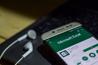 The Microsoft Excel app on a mobile phone with headphones plugged in