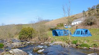 air tents vs pole tents: two tents near a river