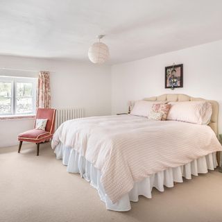 bedroom with white wall chair and white bedlinen