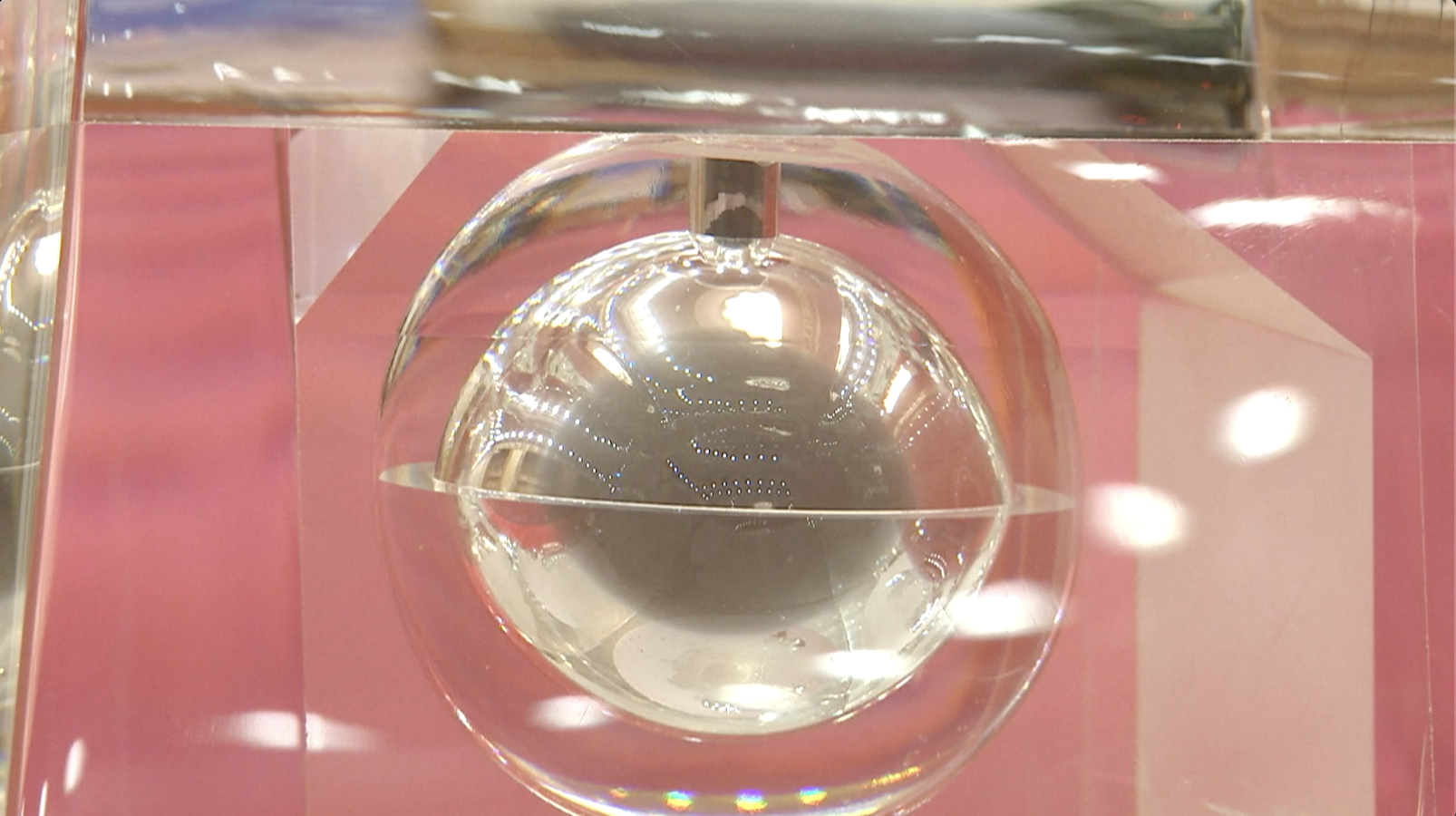 A spherical transparent case with grayish material within.