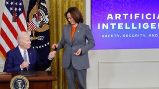 President Biden handing a pen to Vice President Harris after signing an executive order on AI