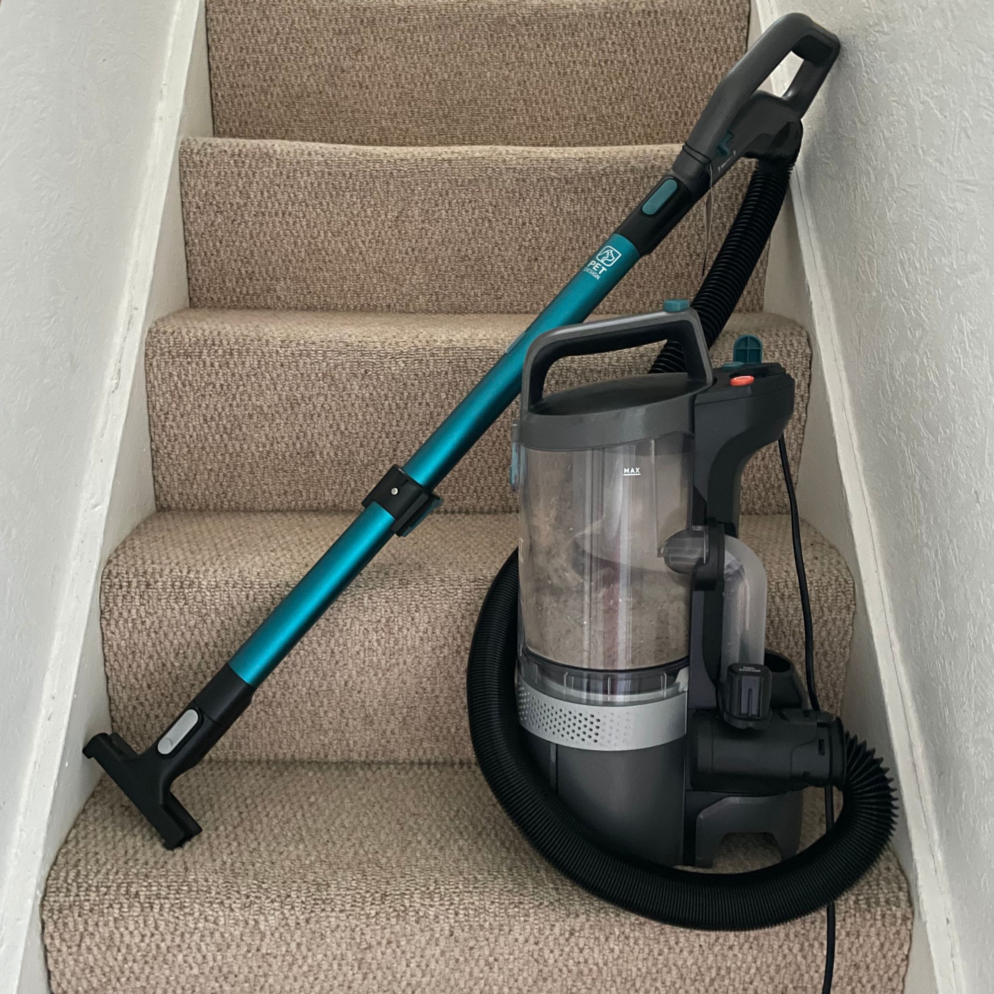 Vax LiftOut Reach Pet-Design Corded Upright Vacuum Cleaner lift-away canister sitting on beige wool carpets on stairs
