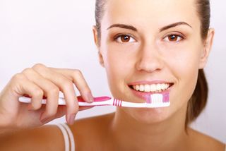 Woman with great teeth holding a toothbrush.
