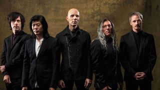 A Perfect Circle posing for a photograph wearing suits