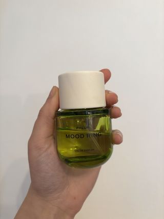 Mica Ricketts holding bottle of Phlur Mood Ring Eau de Parfum