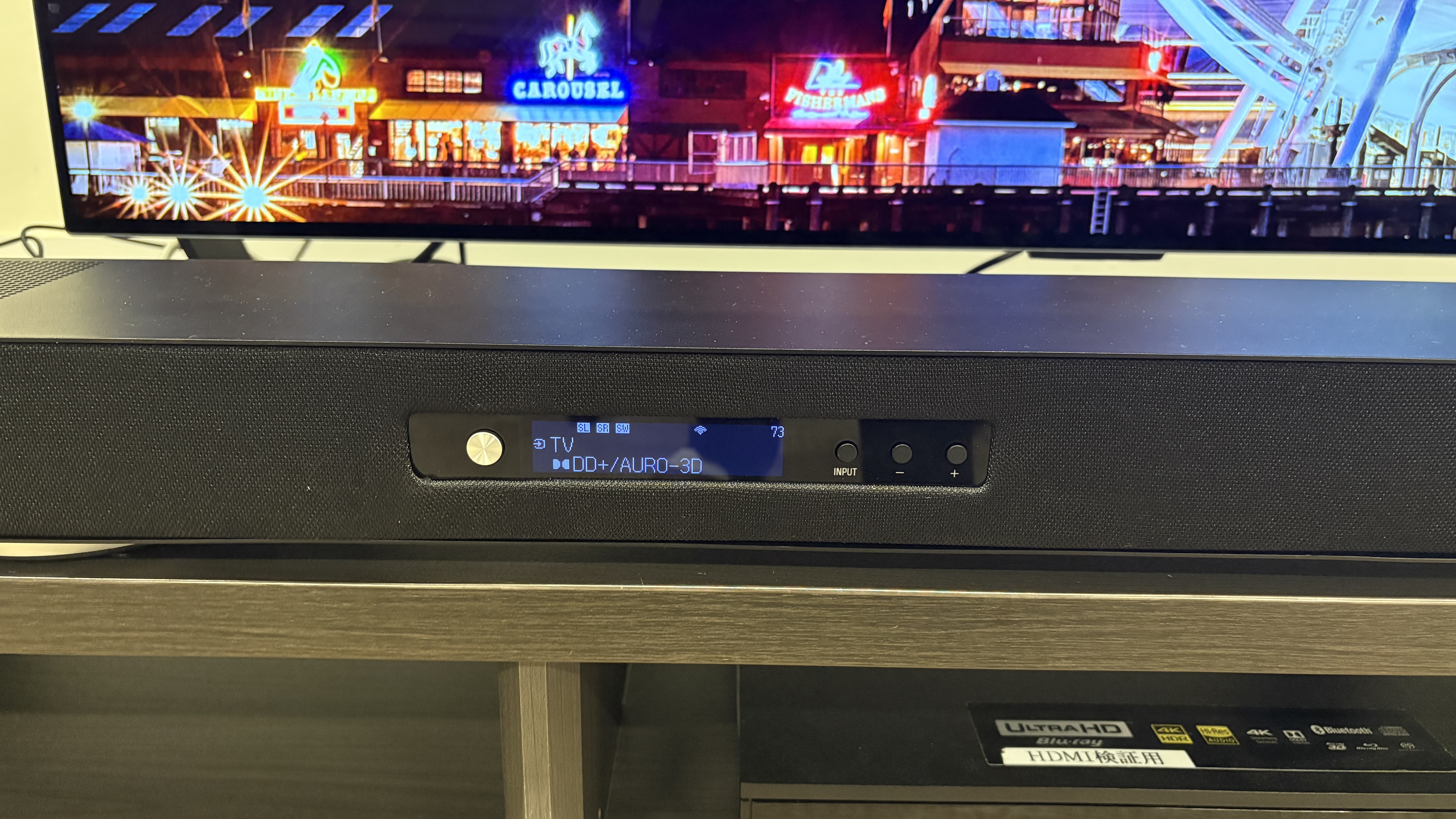 Yamaha True X Surround 90A system (soundbar, surround speakers and subwoofer) in a plain testing room with a TV.