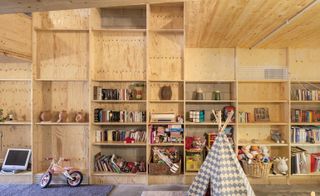 The bespoke wooden shelving running across one of the main walls of the house, means that it has ample storage for the children's toys and books