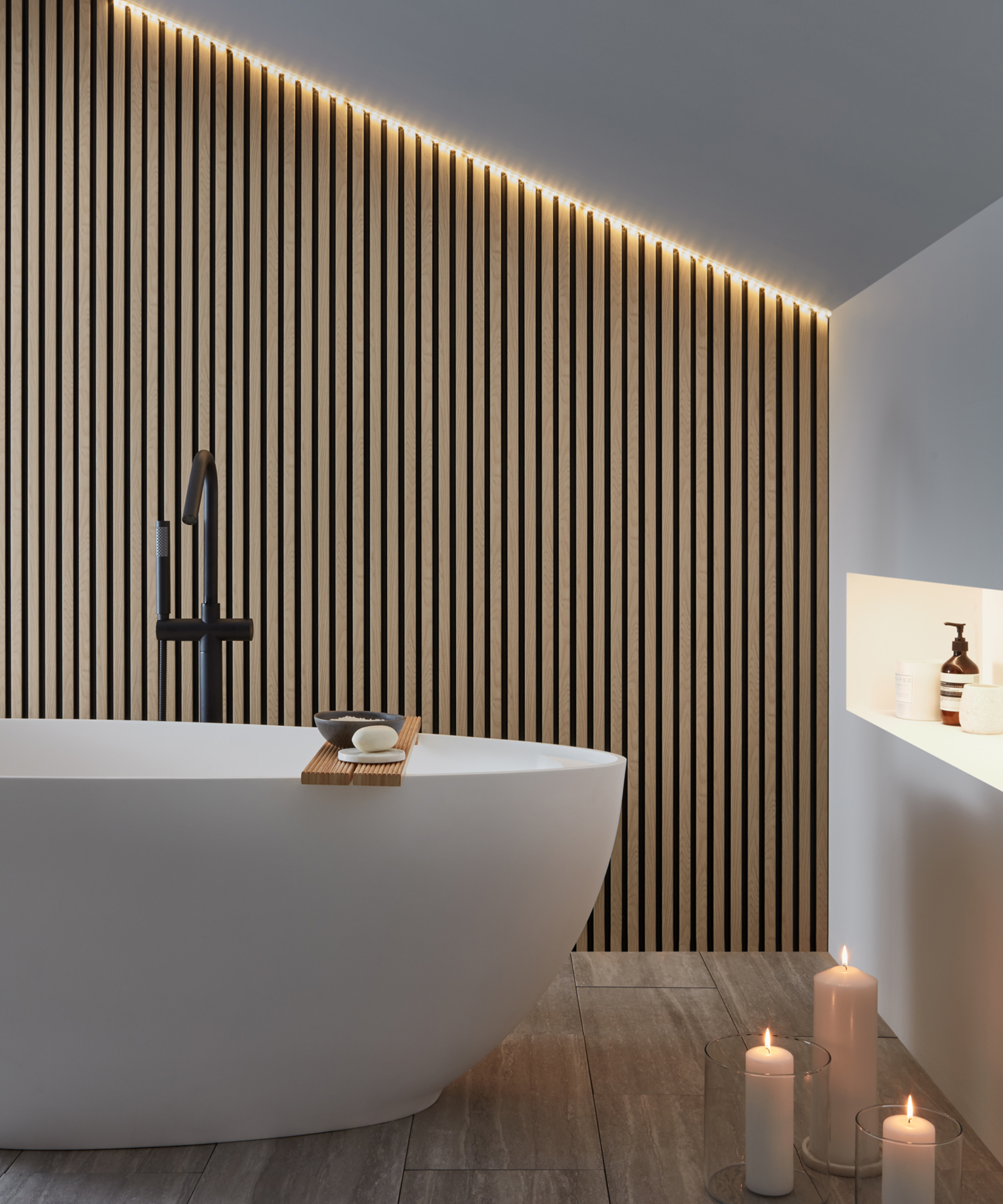bathroom with sloped ceiling, narrow wooden slatted wall with LED lights at top