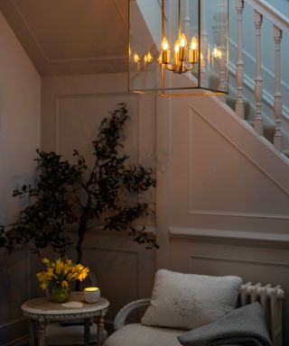 An entryway with a lantern fixture and lit candle on a small table