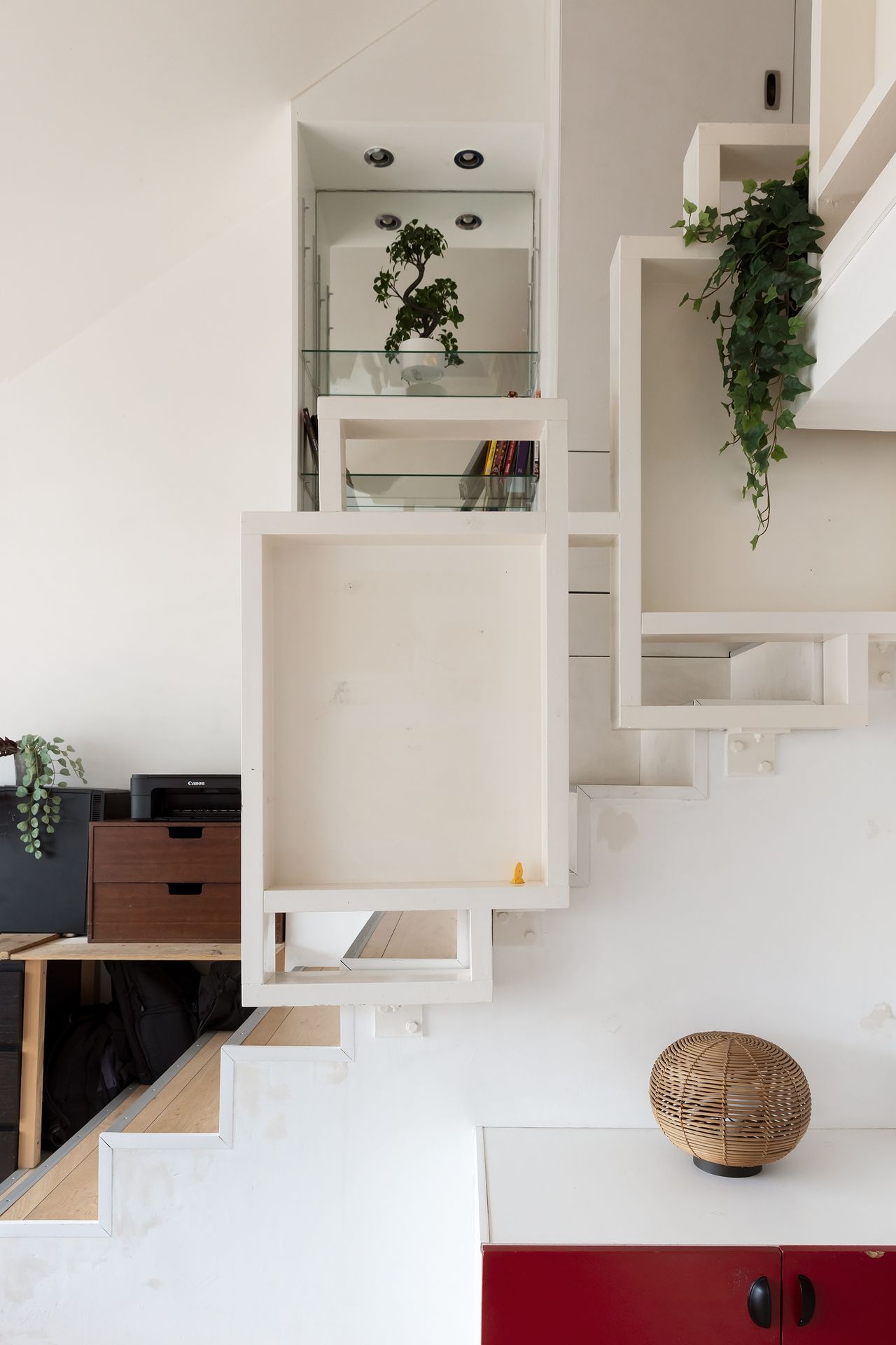 A sculptural staircase links the three levels of the apartment