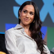 Meghan Markle sits onstage at South by Southwest wearing a button-down shirt