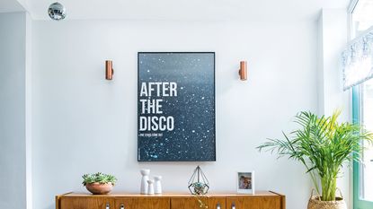 Living room with disco print above wooden sideboard 
