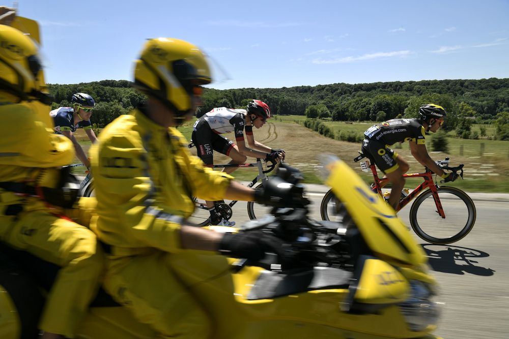 The board girl rides past (From R) France's Perrig Quemeneur, Norway's Vegard Laengen and Belgium's Frederik Backaert riding in a breakaway during the 216 km sixth stage
