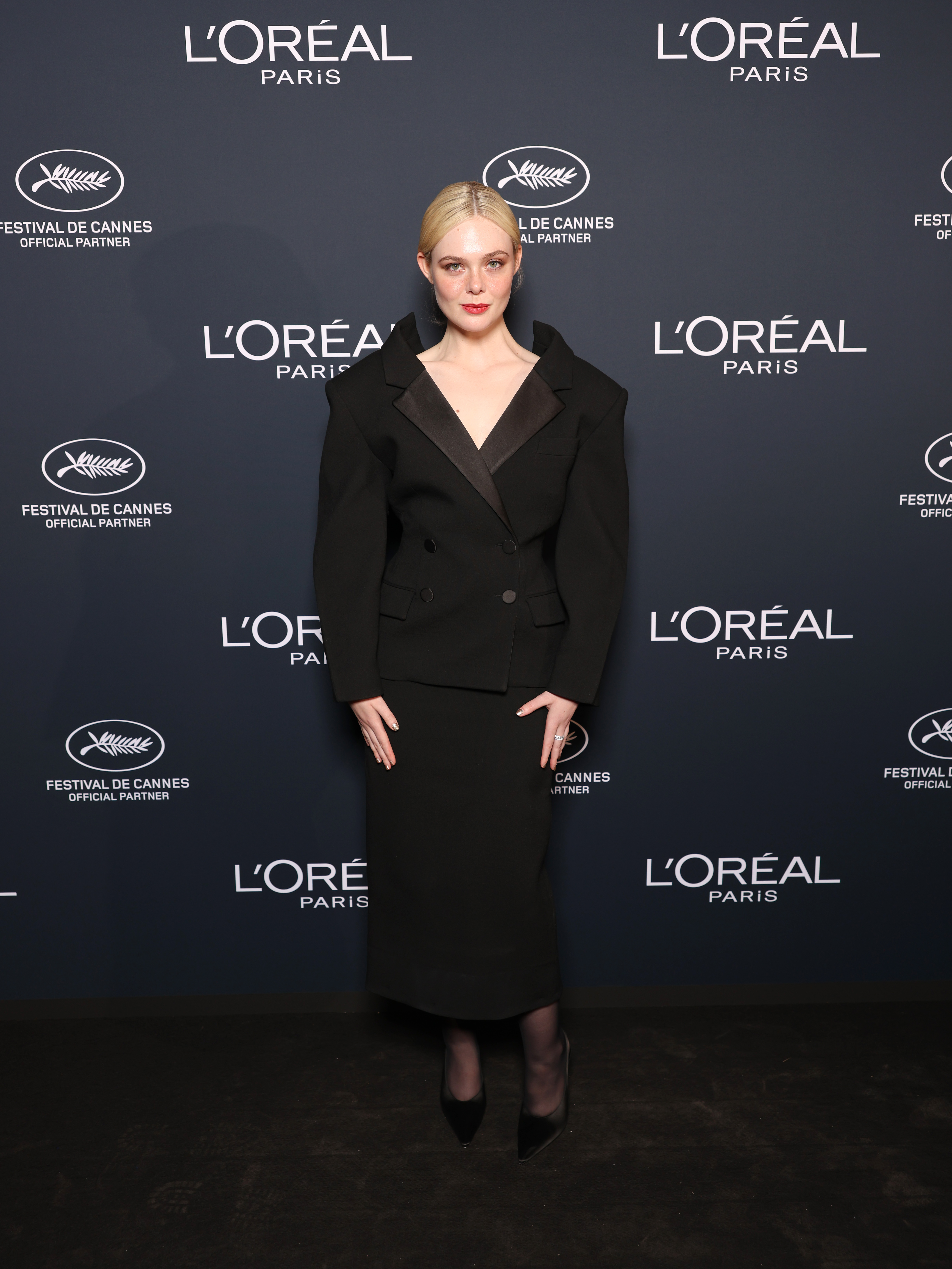 Elle Fanning wears a black Givenchy skirt suit on the red carpet for the L'Oreal Lights on Women's Worth Award at the 78th Cannes film festival on May 23, 2025