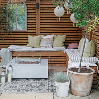 Wood panelled outdoor seating area with fire pit table centrepiece
