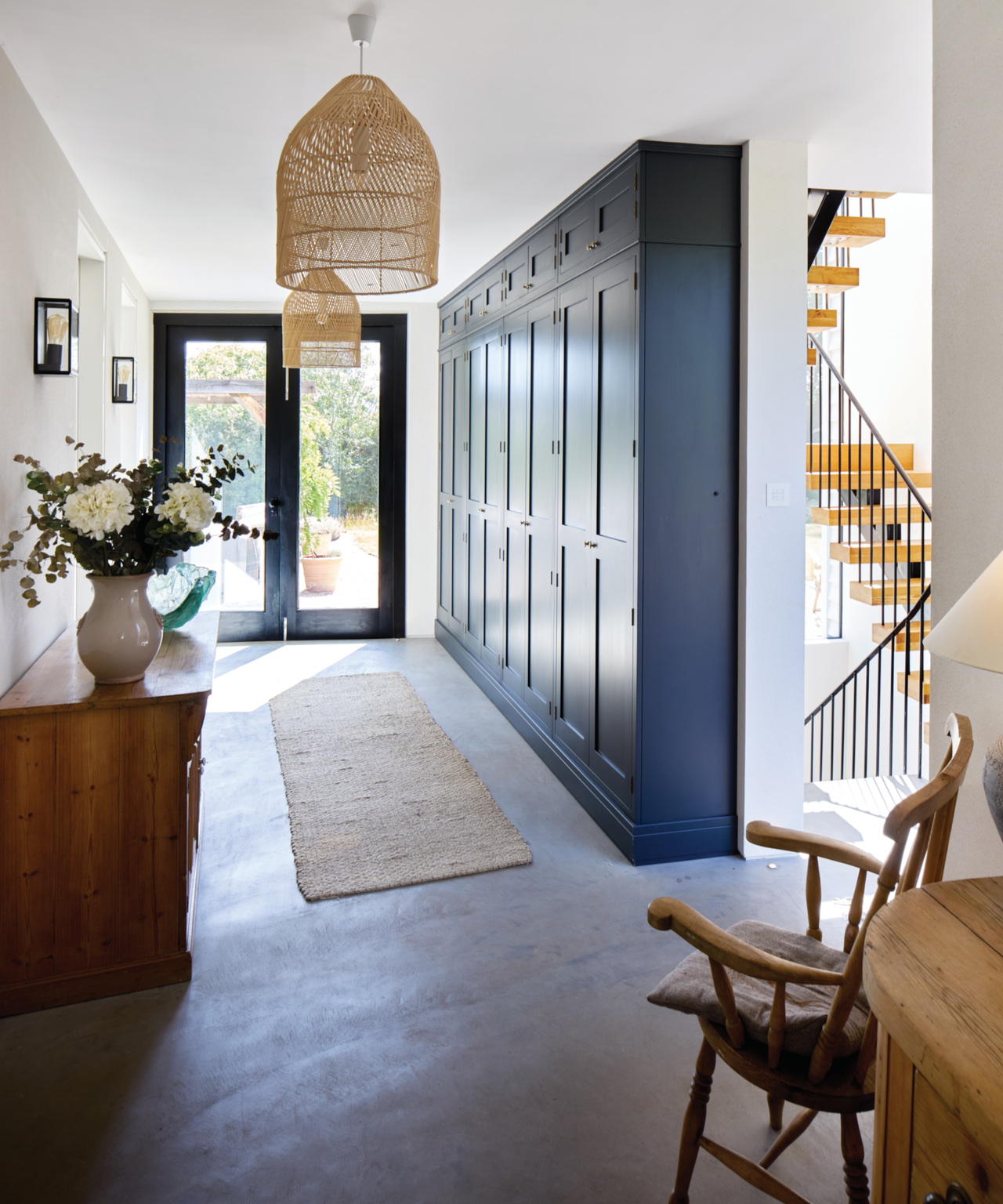 Hallway with rattan lights, blue built in storage, and staircase to the right