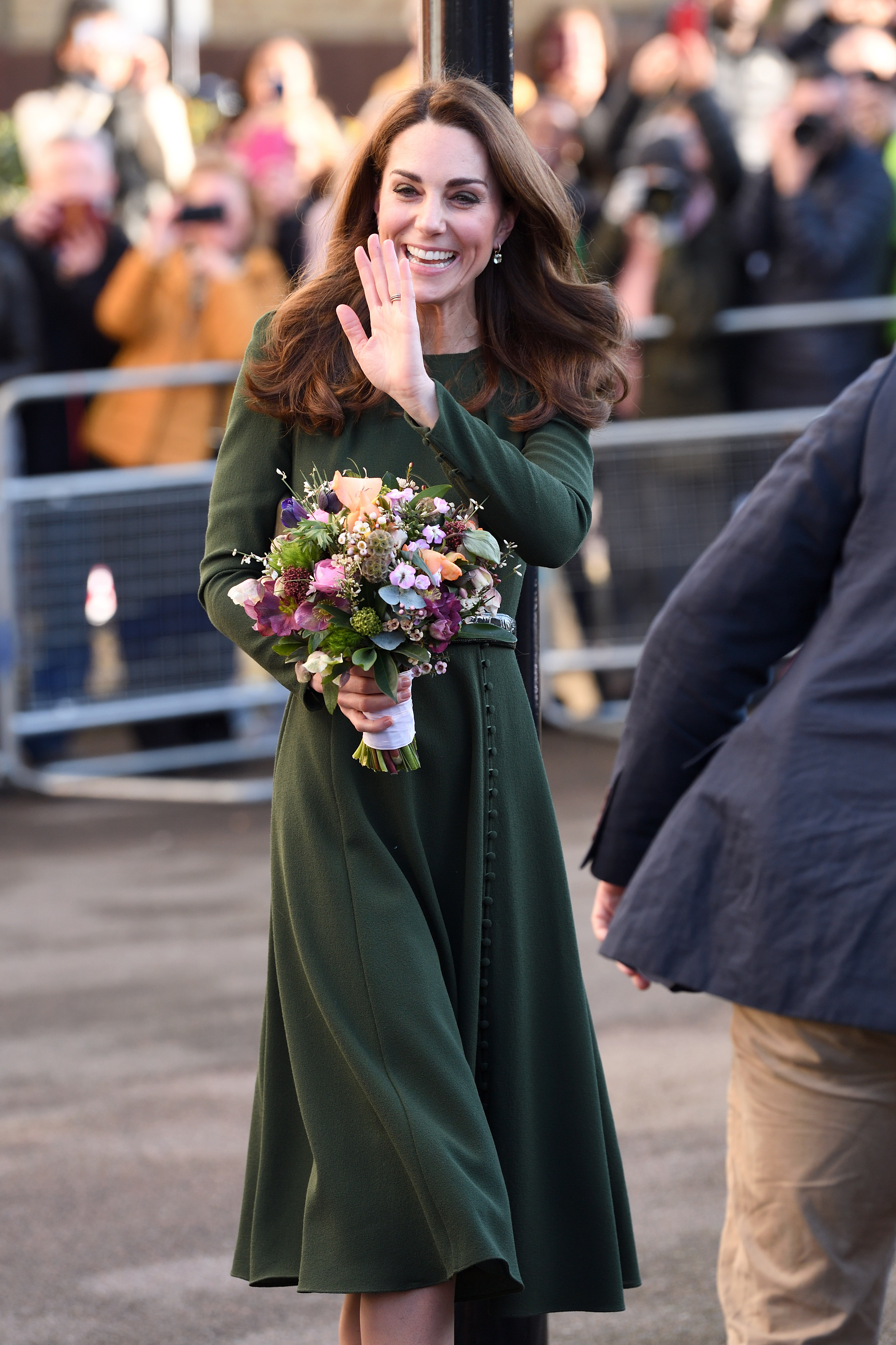 Princess Kate wearing a green dress and waving