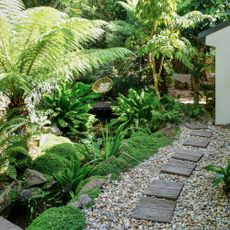 Wooden stepping stones on gravel path in garden