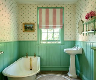 bathroom with bright green tongue and groove panels, a pink and white striped blind and a cream and green polka dot wallpaper