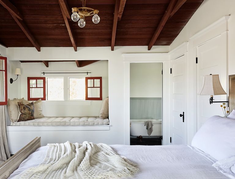 white bedroom with bed nook and wooden ceiling
