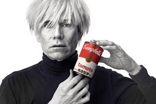 Andy Warhol holding a Campbell's tomato soup can
