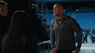 Dwayne Johnson backstage at a WWE show, intimidating two up and coming wrestlers