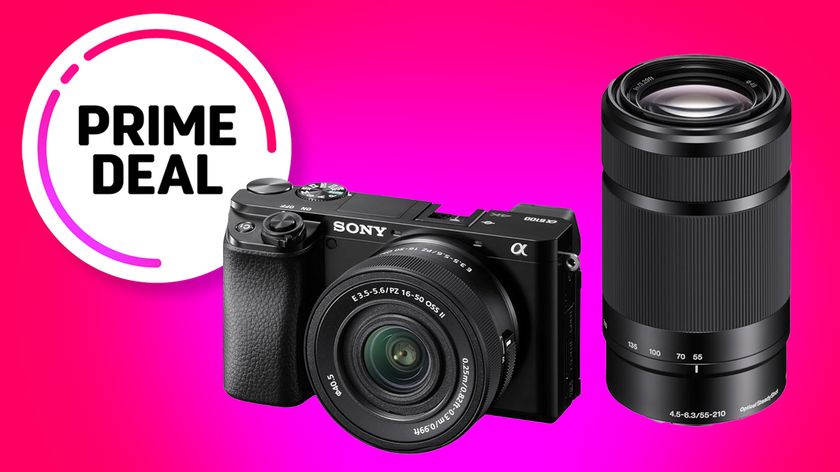 A Sony A6100 camera with a zoom lens on a bright pink background, labeled &quot;Prime Deal.&quot;