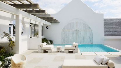 exterior of minimalist home with white walls pool and blue skies